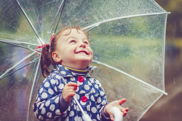 A little girl with an umbrella representing family and children's support services